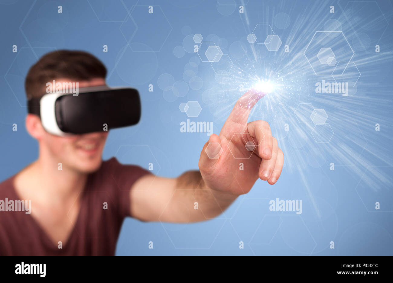 Young impressed man wearing virtual reality goggles with blue hexagons ...