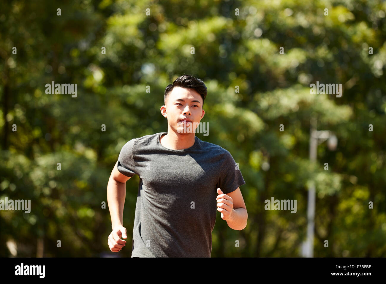 young asian adult man athlete running and training. Stock Photo
