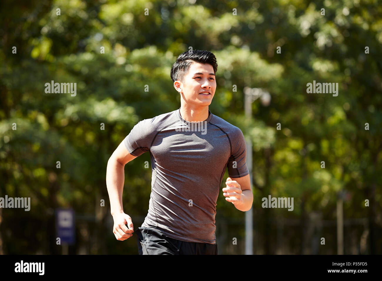 young asian adult man athlete running and training. Stock Photo