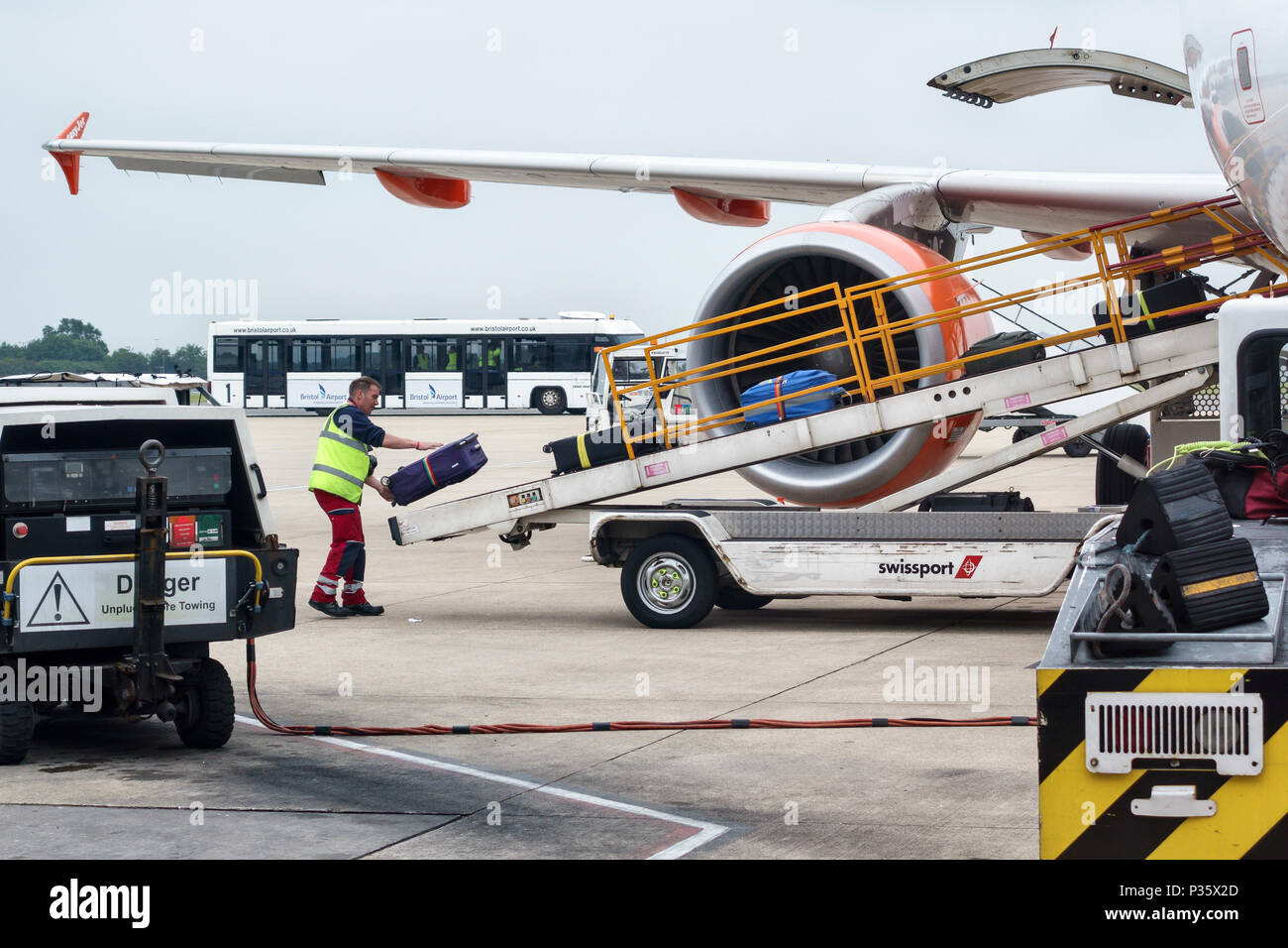 Bristol Airport, UK. A baggage handler loading suitcases onto an Easyjet aircraft Stock Photo