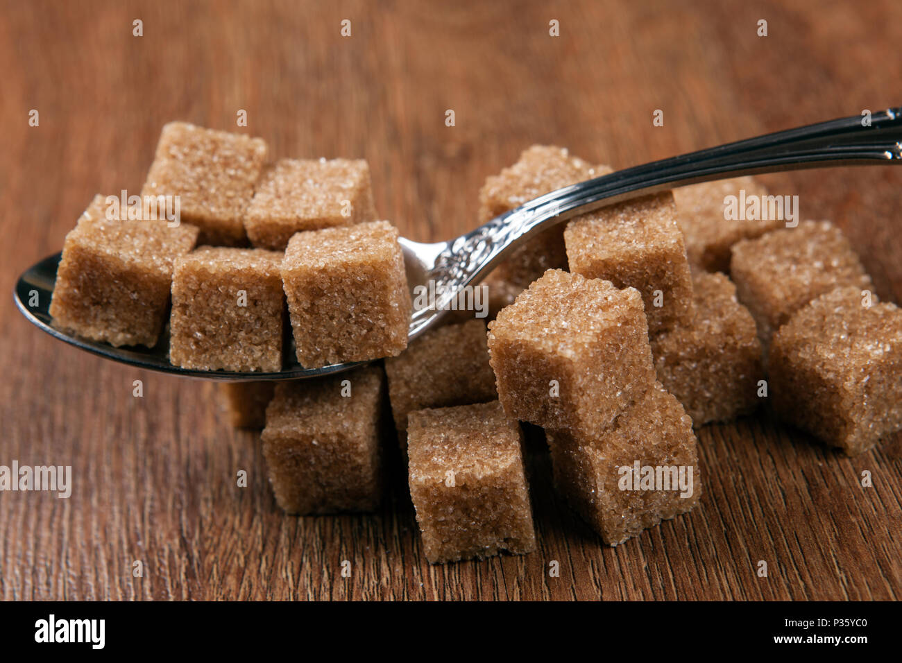 tablespoon with cubes of brown sugar close up Stock Photo Alamy