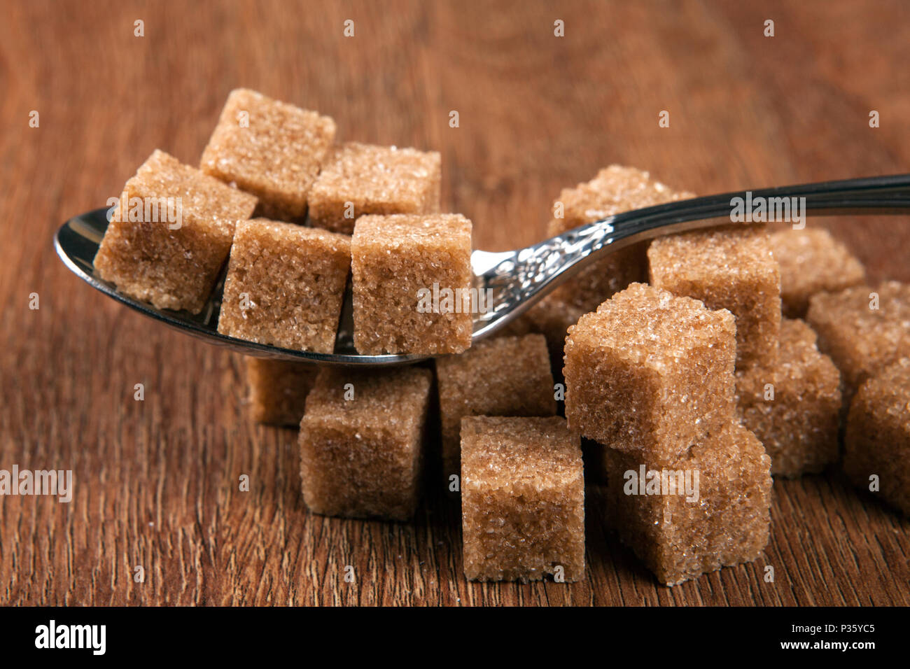 tablespoon with cubes of brown sugar close up Stock Photo Alamy