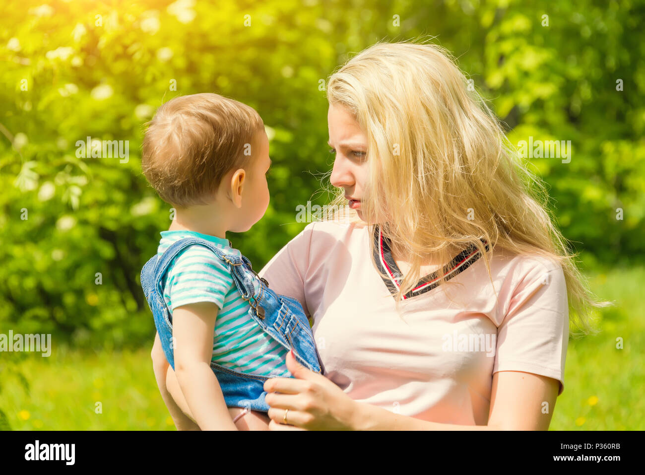 mother and child in nature in the Park, resting on the green grass in ...