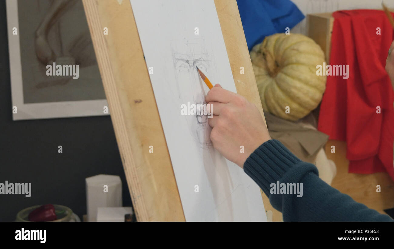 Young man learning to draw classical portrait in studio Stock Photo