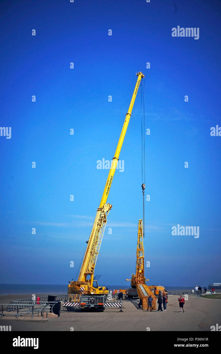 Crane hoisting metal box section of another crane during the ...