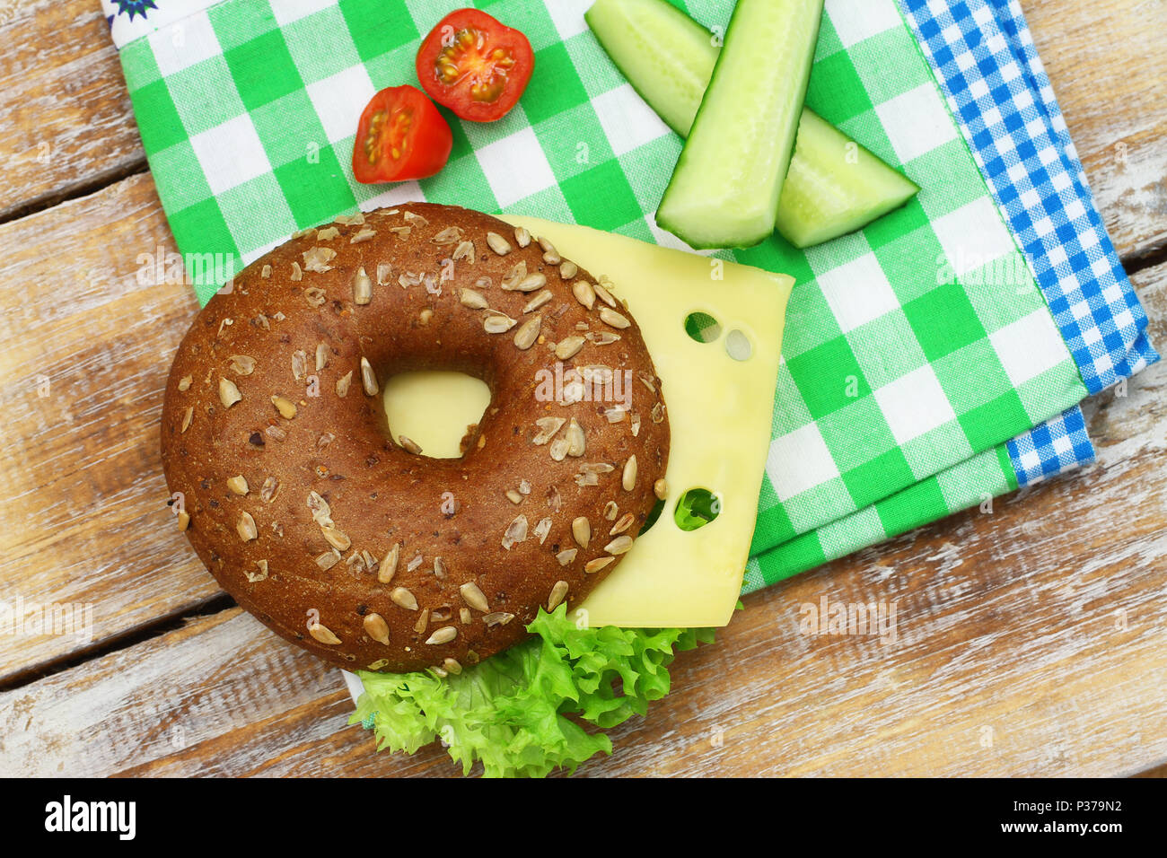 Healthy school lunch consisting of bagel with cream cheese, cucumber