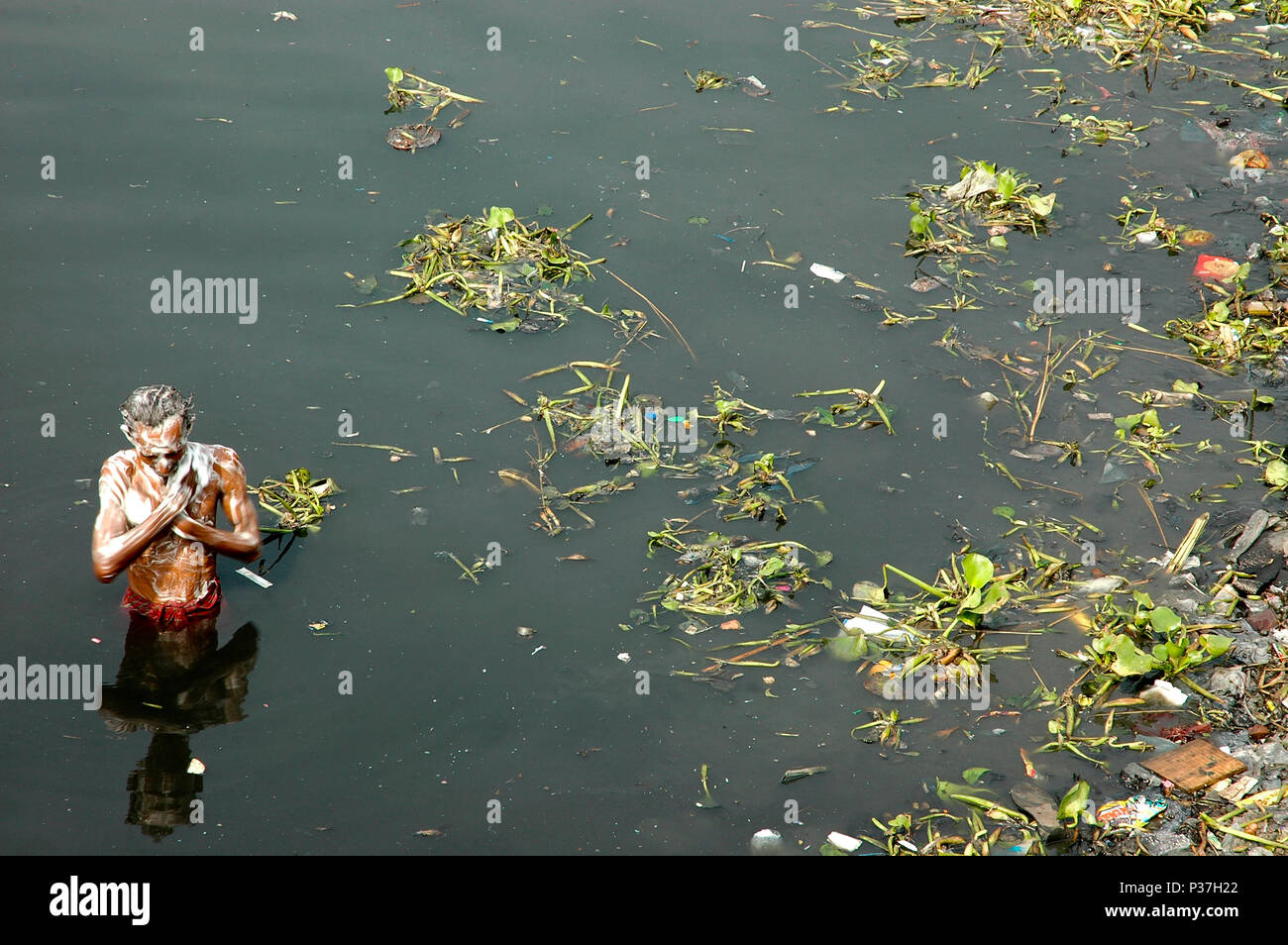 A man taking bath in the poisonous and dirty water of the Buriganga