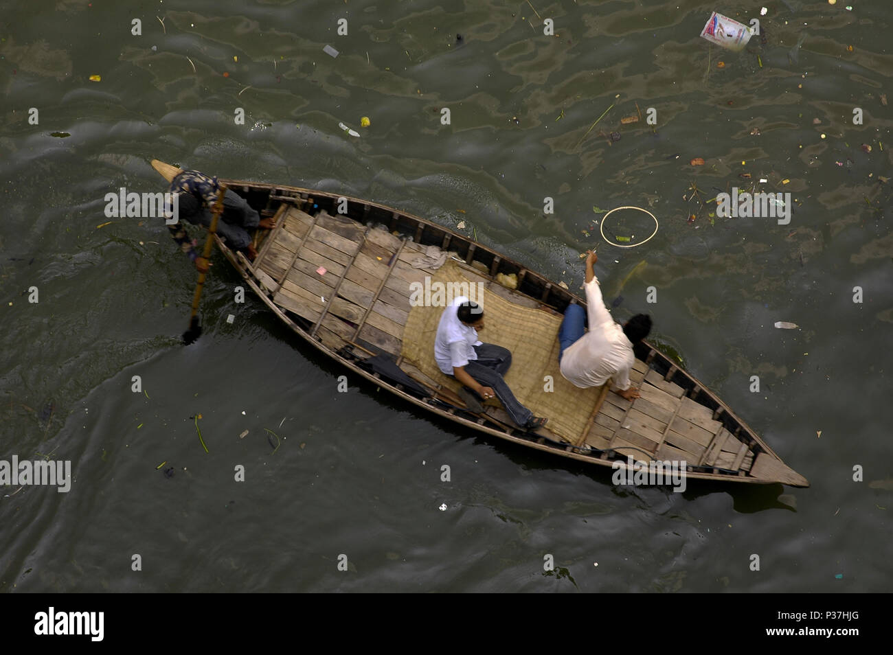 A boat on the Buriganga River. Water of Buriganga River has turned black due to dumping of industrial waste. Dhaka, Bangladesh Stock Photo