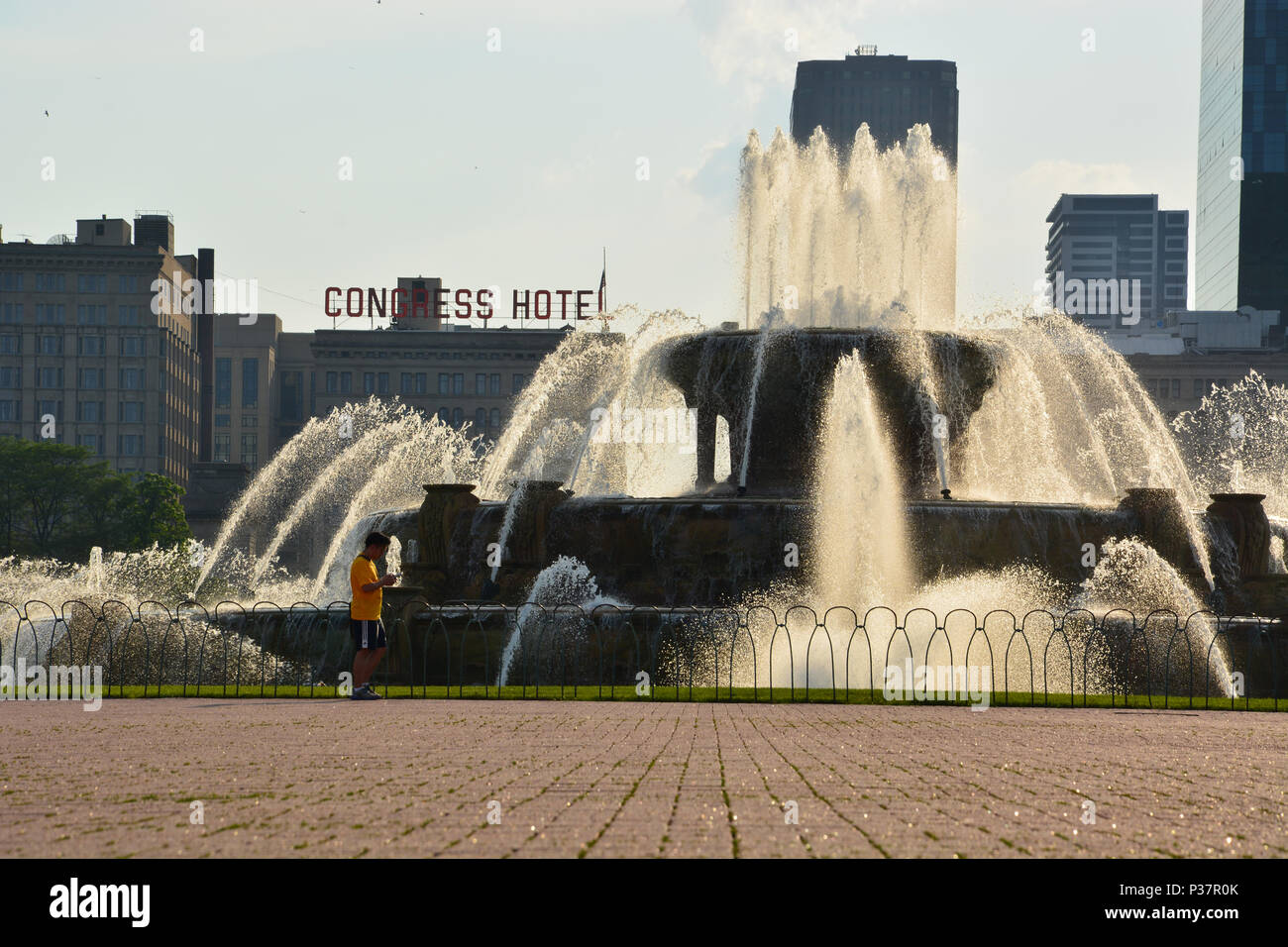 The late afternoon sun illuminates the Buckingham Fountain from behind in Chicago's Grant Park. Stock Photo