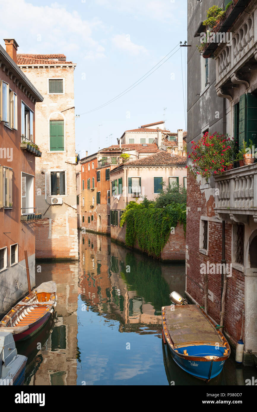 Sunset on a tranquil canal in Cannaregio, Venice,  Veneto, Italy with boats and reflections Stock Photo