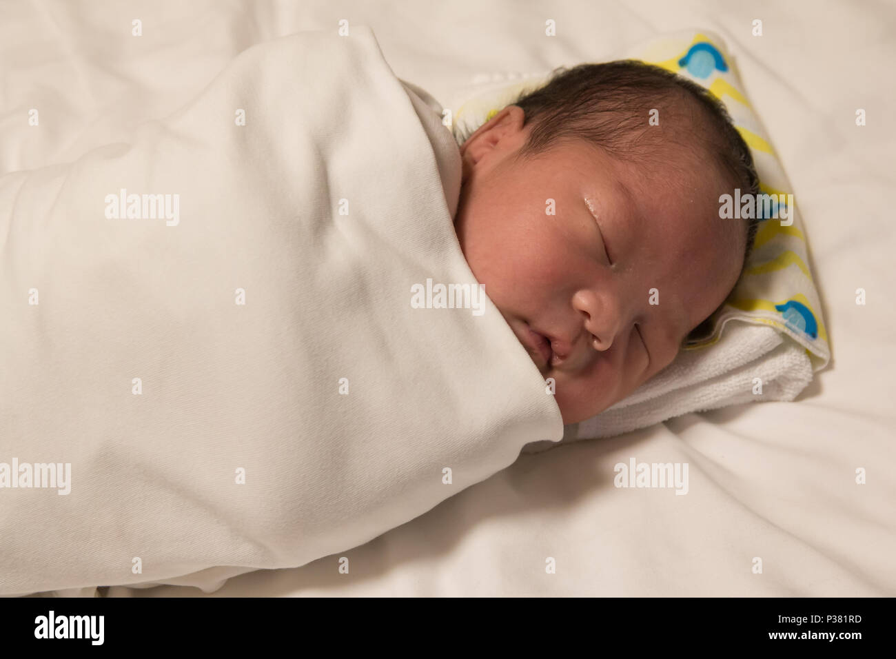 An Asian new born baby falling into a deep sleep Stock Photo