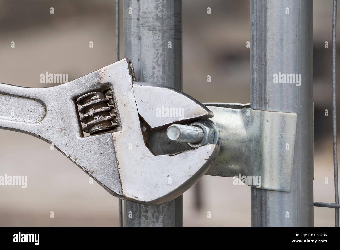 Adjustable spanner gripping bolt nut on construction clamp Stock Photo