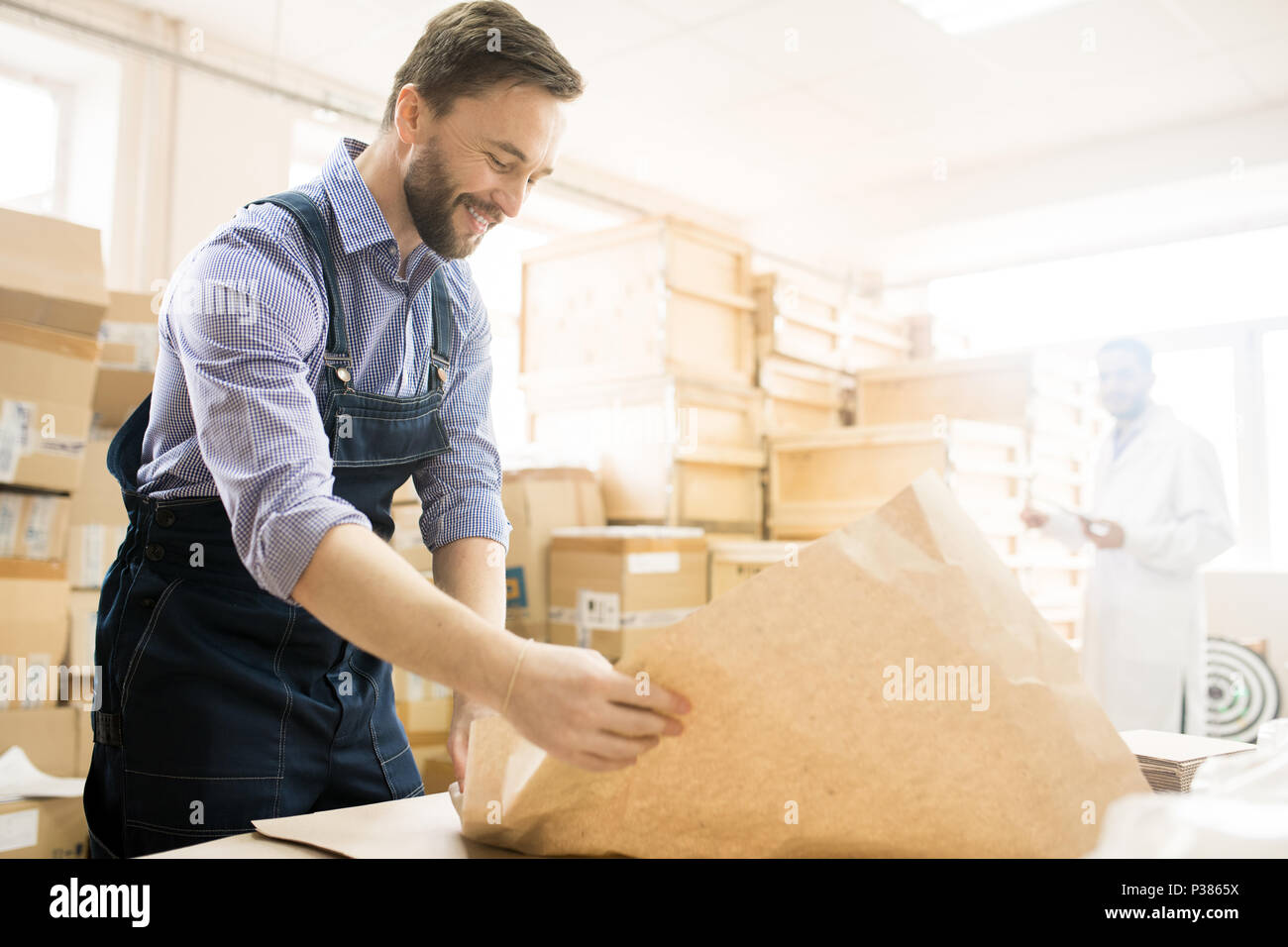 Smiling Warehouse Worker Packaging Equipment Stock Photo - Alamy
