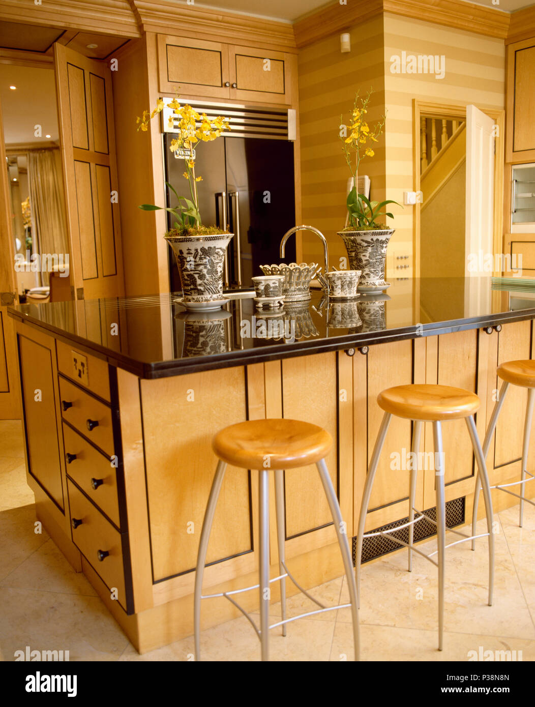 Metal+wood stools at breakfast bar on topped island unit in modern