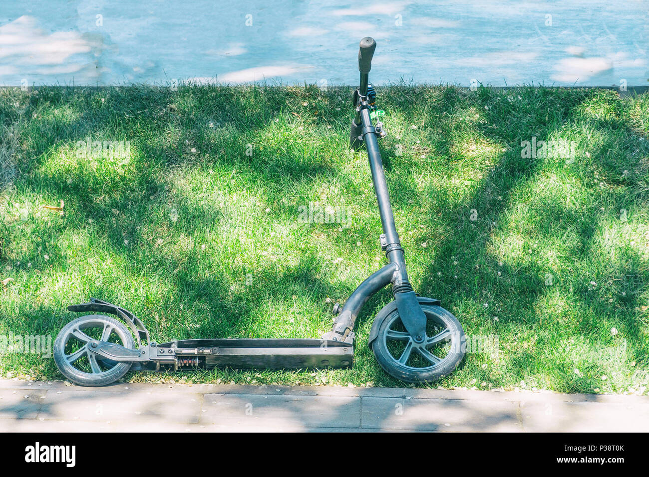 Children's scooter of black color on grass Stock Photo Alamy