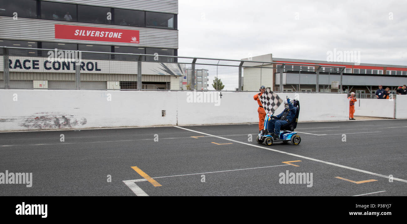 Silverstone GP circuit, UK. 17th Jun, 2018. During the HSCC Silverstone International race meeting Noel Wilson set out in his mobility scooter to set a new lap record on the full GP circuit. Aiming to raise £20,000 for MS research he is trying to set a record on every track in the country Credit James Wadham / Alamy Live News Stock Photo