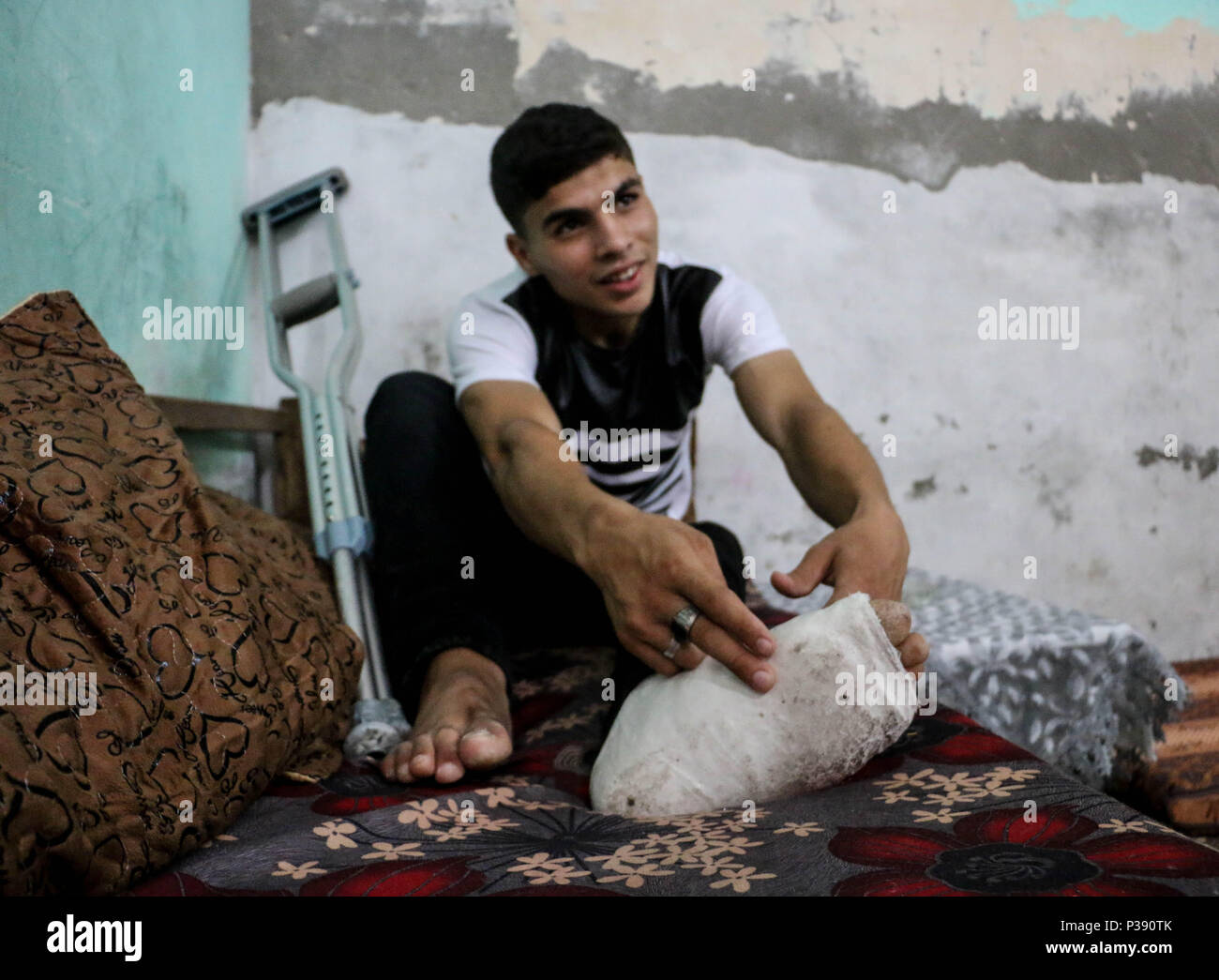 Ahmed puts his hand on his foot in his home in al-Bureij refugee camp, the  second day of Eid al-Fitr, celebrated by Muslims. Ahmed Jawad Mahmoud  Othman a 19-year-old Palestinian youth from