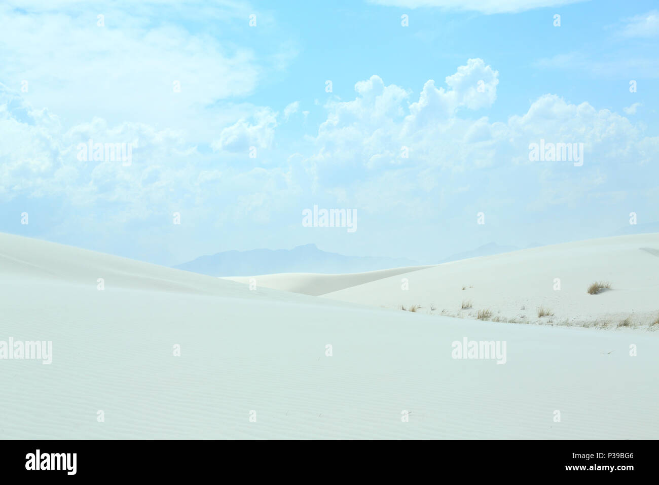 White sand dune with wind formed ripples on a day with blue skies and clouds Stock Photo