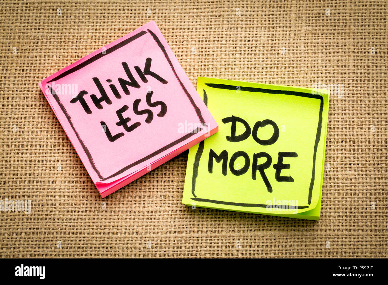 think less, do more reminder - inspirational handwriting on sticky notes against burlap canvas Stock Photo