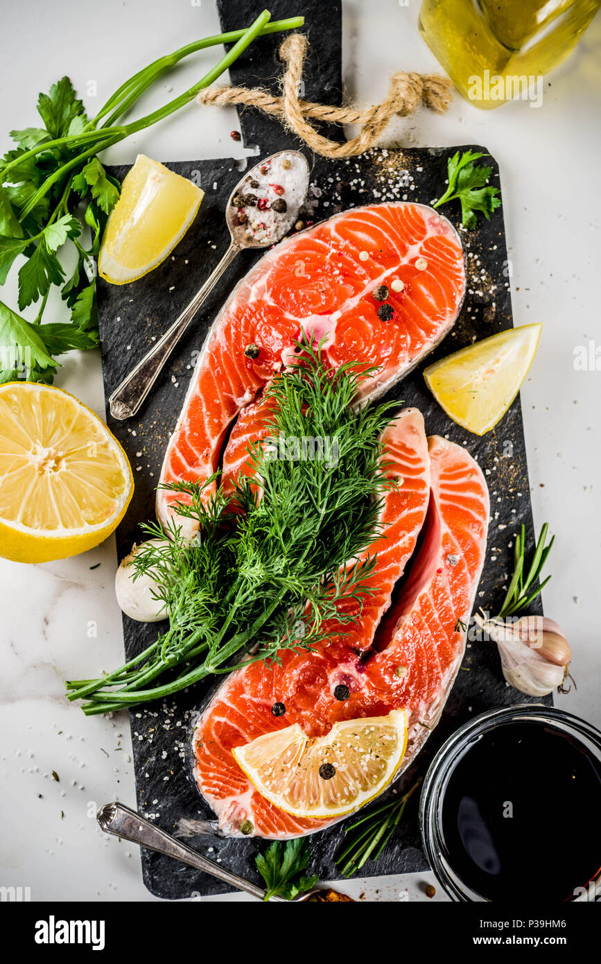 https://c8.alamy.com/comp/P39HM6/raw-salmon-fish-steaks-with-lemon-herbs-olive-oil-ready-for-grill-slate-cutting-board-white-marble-background-copy-space-above-P39HM6.jpg