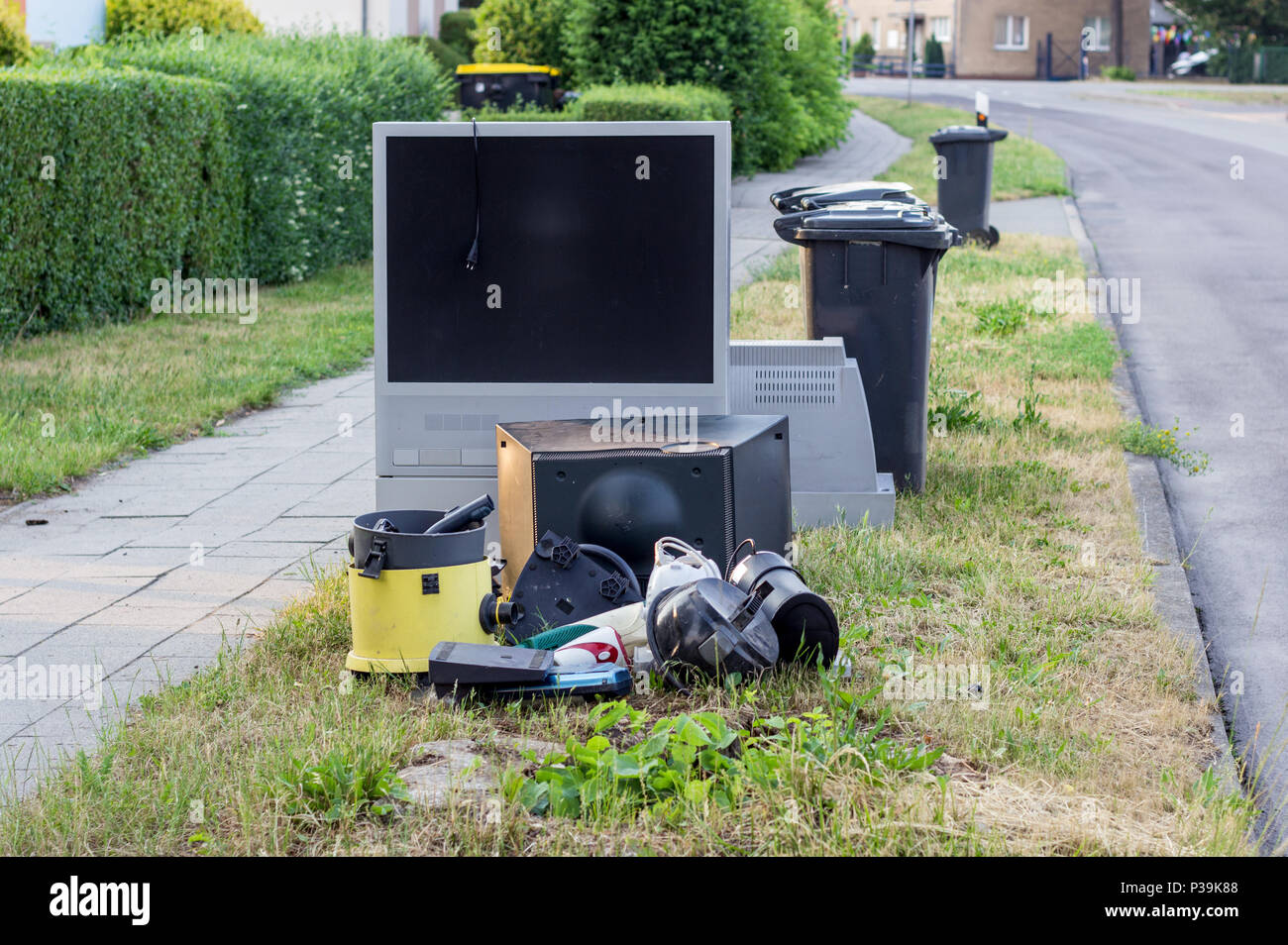 electronic garbage with a television, vacuum cleaner and other electrical appliances on the roadside Stock Photo