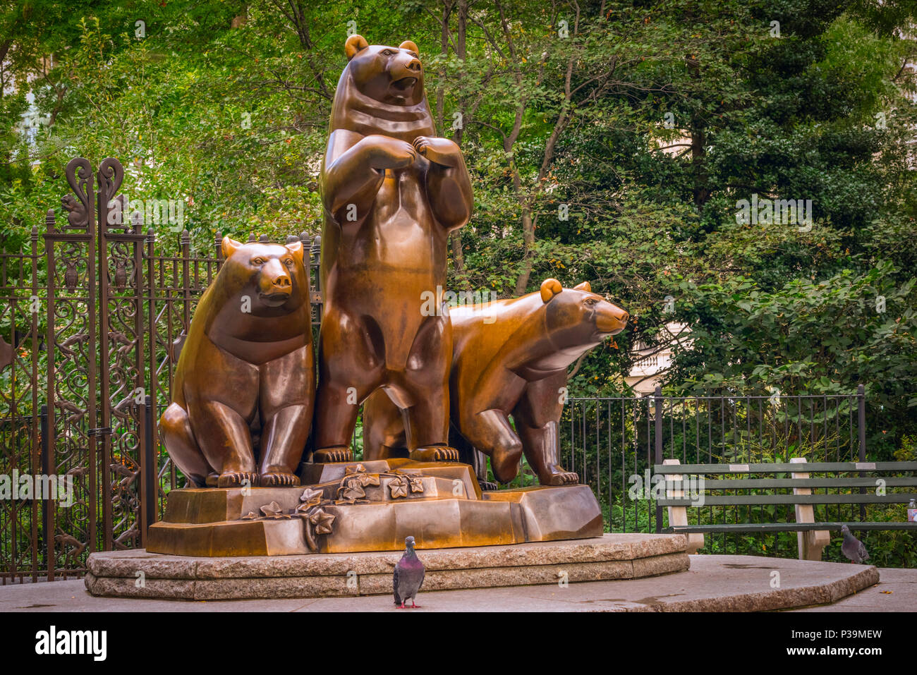 Pigeon poses in front of the Group of Bears sculpture, by Paul Manship, in Central park, Manhattan, New York City Stock Photo