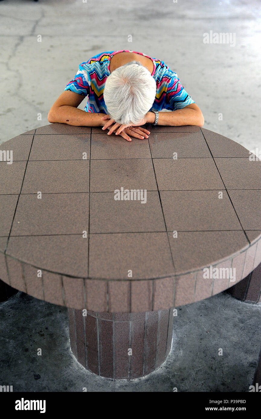 Singapore, Republic of Singapore, a woman is resting at a table Stock Photo