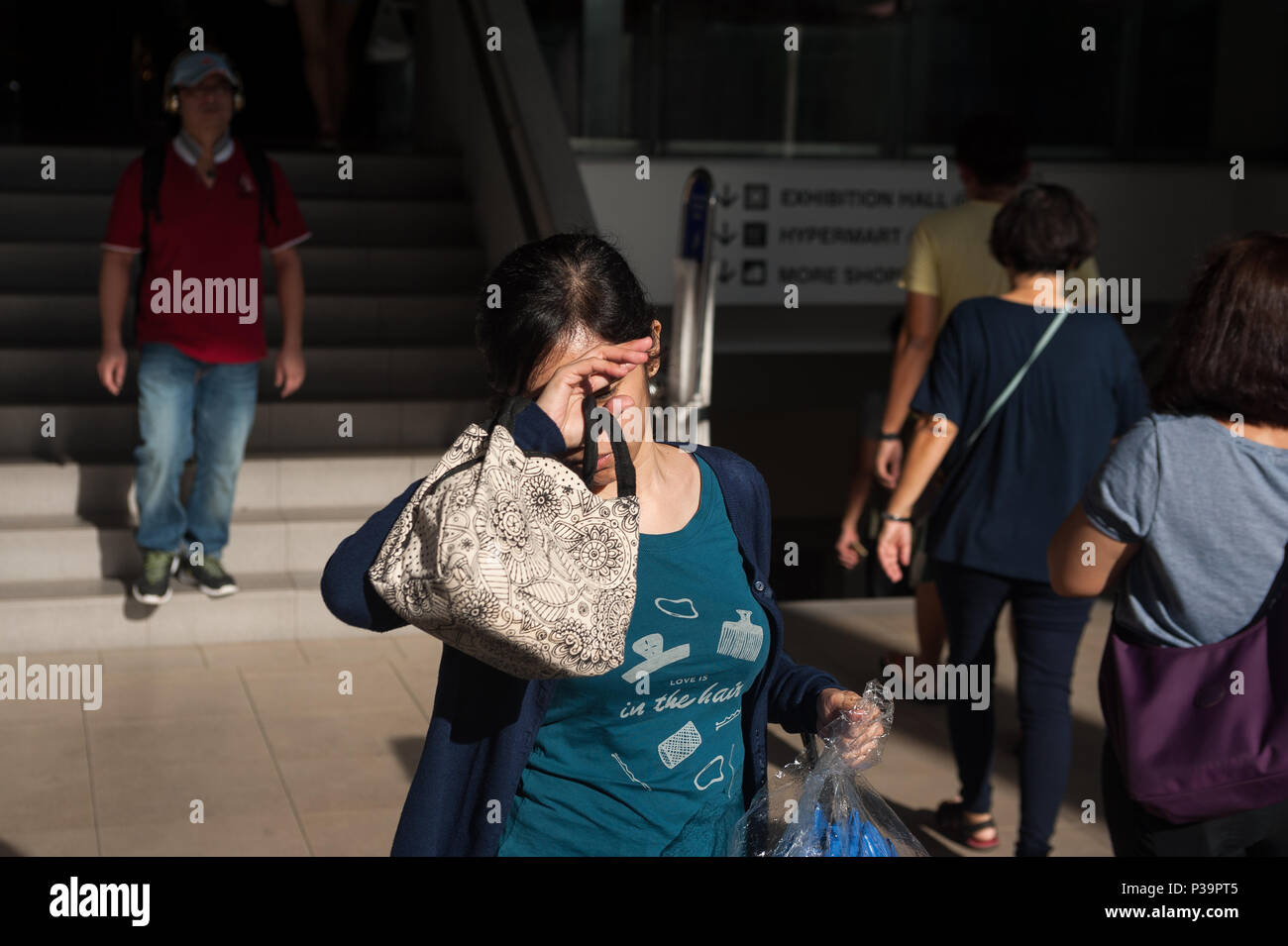 Singapore, Republic of Singapore, woman protects her face from the sun Stock Photo