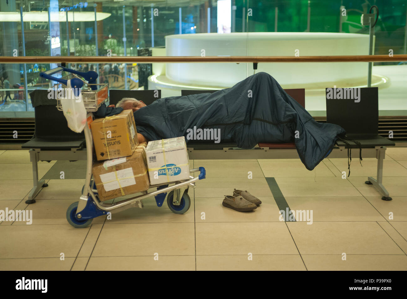 Singapore, Republic of Singapore, sleeping passenger in Changi Airport Terminal 3 Stock Photo