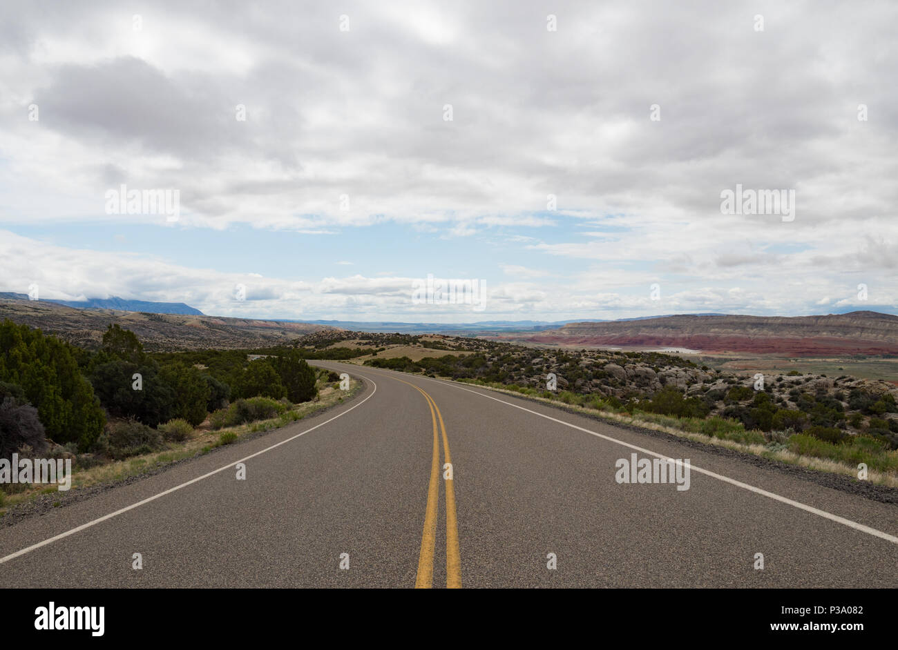 The center line of a highway in the Bighorn Canyon National Recreation Area with cloudy skies above. Stock Photo