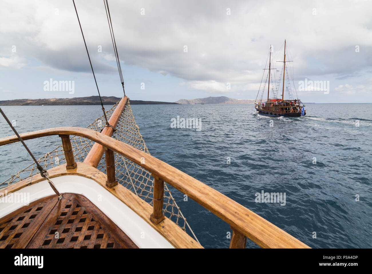 SANTORINI, GREECE - MAY 2018: Old wooden ships sailing in Mediterranean sea  towards the volcano caldera. View from the bow of the ship Stock Photo -  Alamy