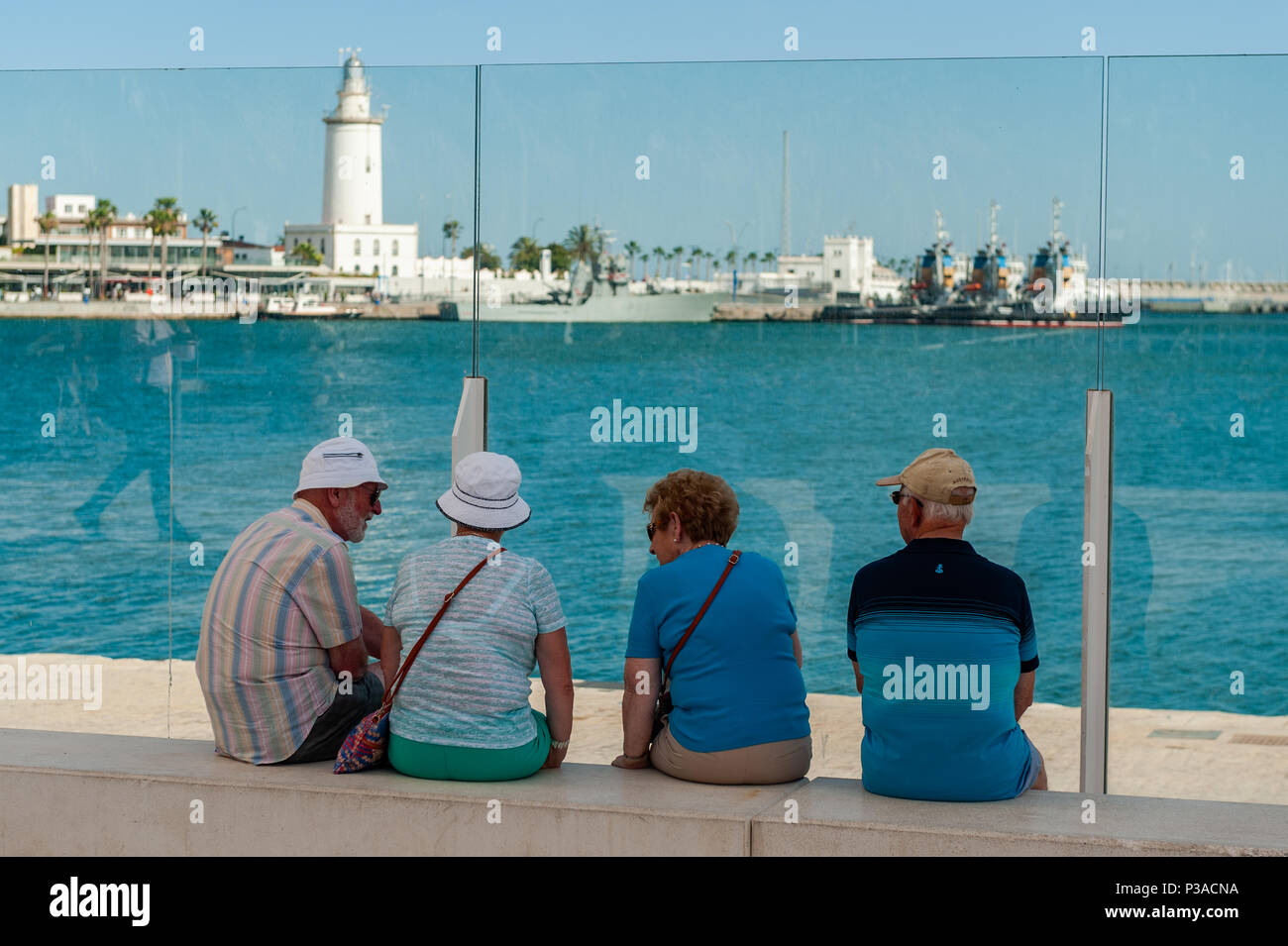 Tourists chat to each other in Malaga Marina, Malaga, Spain with copy space. Stock Photo