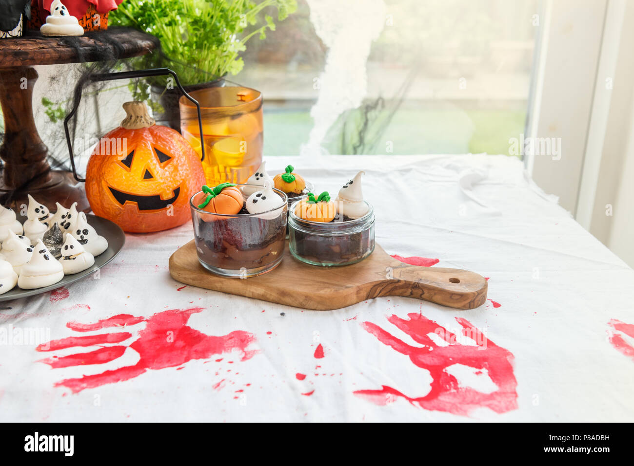 Table Set for Halloween Dinner with lots of Sweets, Pumpkin,  Jack-o-Lantern, Cupcakes, Cookies, Bloody Jelly, Spiders, Web and other  Halloween related Stock Photo - Alamy