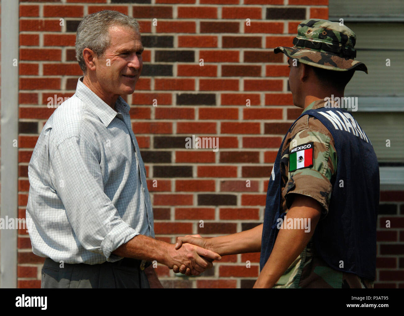 Miss. (Sept. 12, 2005) - President George W. Bush conveys his gratitude to a marine from the Federal Republic of Mexico, on their clean up efforts at 28 Street Elementary School in Biloxi, Miss. President Bush is currently visiting the Gulf Coast region to assess the damage and disaster recovery efforts from Hurricane Katrina. The Mexican Navy is assisting the U.S. Navy in providing humanitarian assistance to victims of Hurricane Katrina. The Navy's involvement in the humanitarian assistance operations are being led by the Federal Emergency Management Agency (FEMA), in conjunction with the Dep Stock Photo