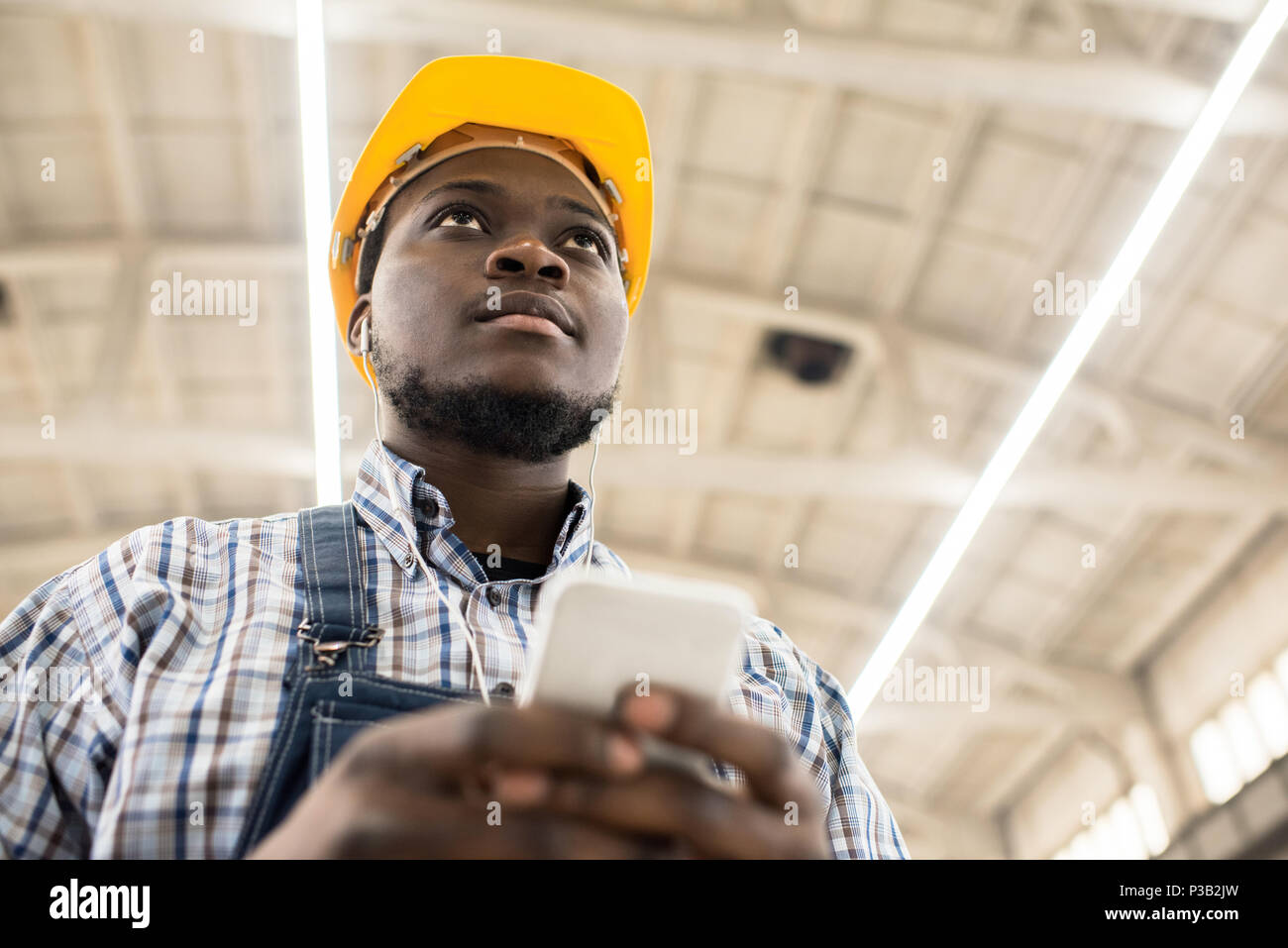 Pensive engineer texting sms at construction site Stock Photo