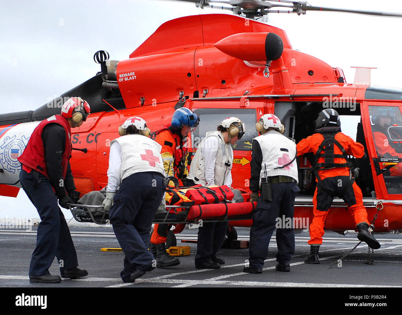 OCEAN (Dec. 14, 2008) An injured merchant sailor from the Liberian cargo ship 'Marie Rickmers' is loaded onto a Coast Guard MH-65 Dolphin helicopter after receiving basic medical attention aboard the aircraft carrier USS Abraham Lincoln (CVN 72). The Sailor was taken to Abraham Lincoln the previous night by a San Diego Coast Guard helicopter and medically stabilized before being flown to San Francisco for treatment. Abraham Lincoln is underway conducting training and carrier qualifications. Stock Photo