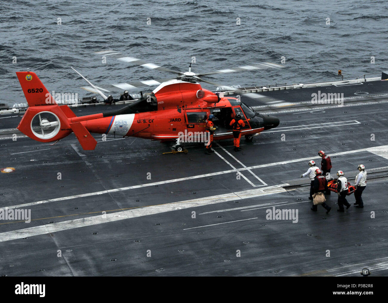 OCEAN (Dec. 14, 2008) An injured merchant sailor from the Liberian cargo ship 'Marie Rickmers' is loaded onto a Coast Guard MH-65 Dolphin helicopter after receiving basic medical attention aboard the aircraft carrier USS Abraham Lincoln (CVN 72). U.S. Navy Stock Photo