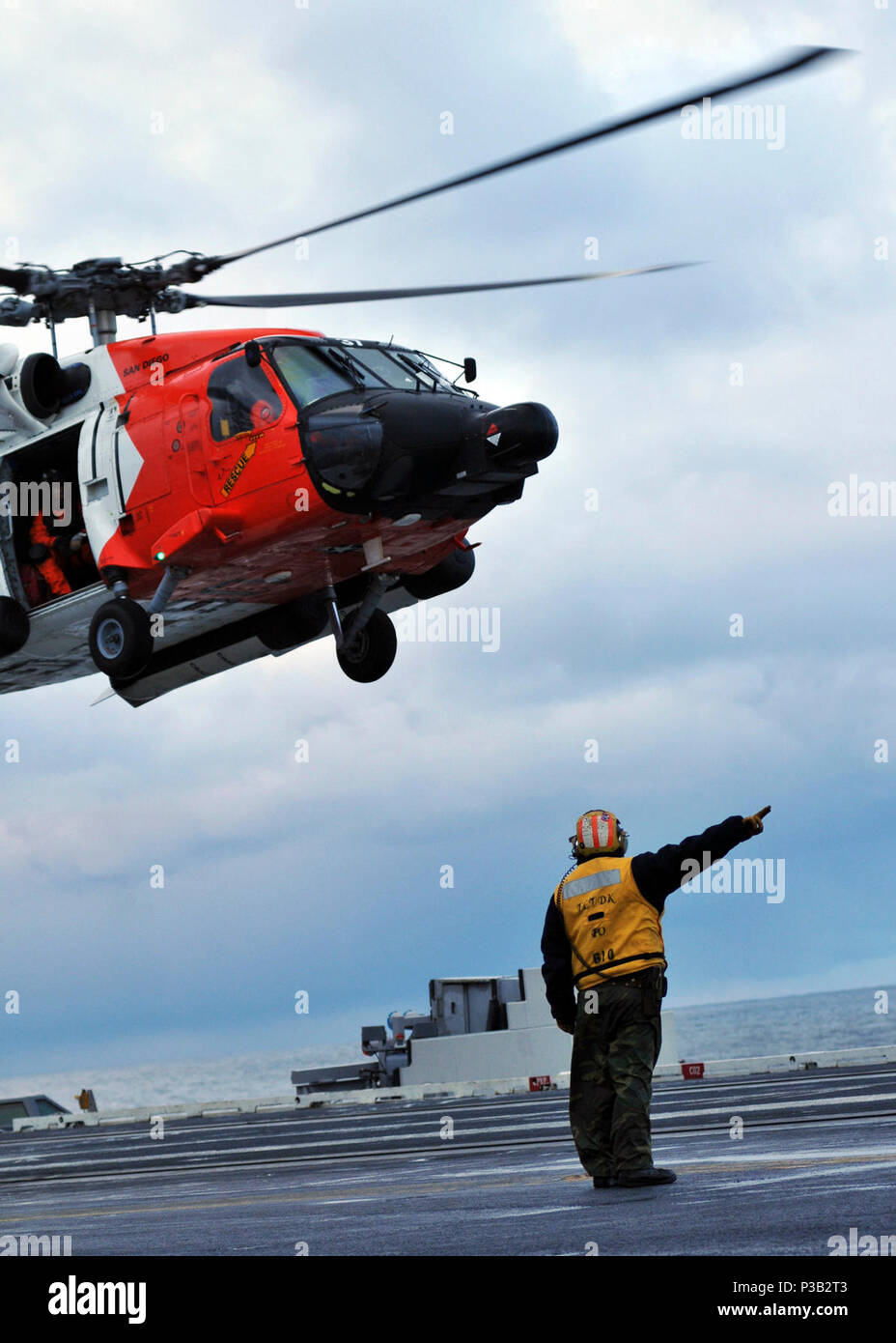 OCEAN (Dec. 15, 2008) Aviation Boatswain's Mate (Handling) 1st Class Jerry Pitts, from Santa Maria, Calif., directs a U.S. Coast Guard HH-60 helicopter for launch from the flight deck of the aircraft carrier USS Abraham Lincoln (CVN 72). The helicopter participated in the evacuation of an injured merchant Sailor to Abraham Lincoln. The sailor was medically stabilized and flown to San Francisco for treatment. Lincoln is underway conducting training and carrier qualifications. Stock Photo