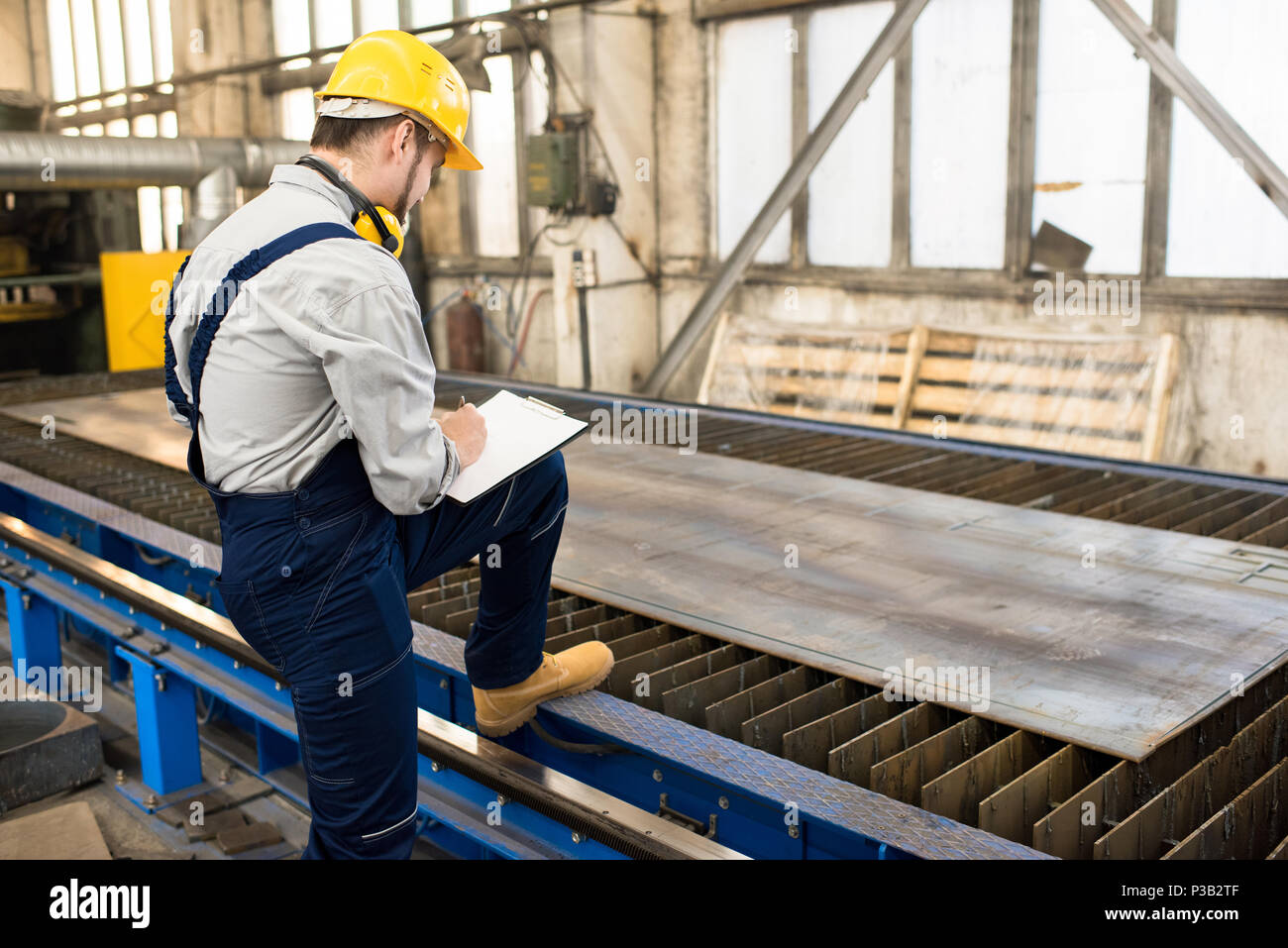 Engineer analyzing quality of metal sheet Stock Photo Alamy