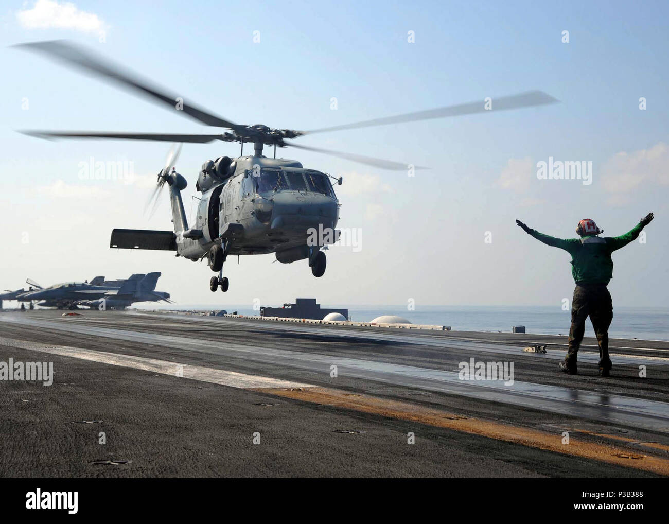 OF OMAN (Dec. 18, 2008) Cmdr. Scott 'Scotty High' Starkey lands an SH-60F Sea Hawk on the flight deck of the aircraft carrier USS Theodore Roosevelt (CVN 71) after his in-air change of command ceremony. Starkey relieved Cmdr. Mark 'Bad Andy' Truluck as commanding officer of the 'Tridents' of Helicopter Anti-Submarine Squadron (HS) 3. Theodore Roosevelt and Carrier Air Wing (CVW) 8 are conducting operations in the U.S. 5th Fleet area of responsibility and are focused on reassuring regional partners of the United States' commitment to security, which promotes stability and global prosperity. Stock Photo