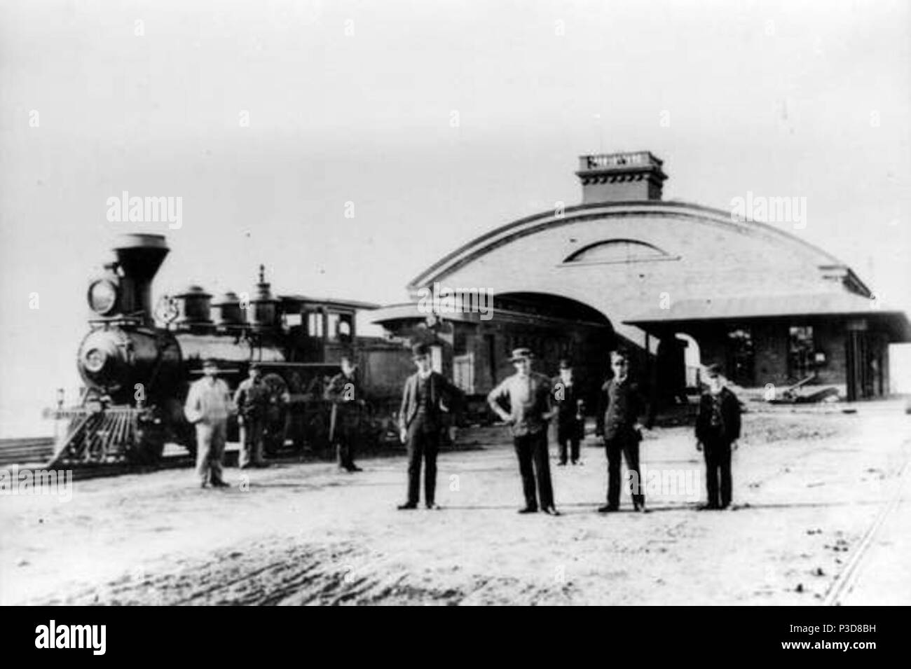 . English: Old Colony Railroad' station at Fairhaven, Massachusetts, on the Fairhaven Branch, circa 1880. The locomotive pictured is OCRR #7, The 'Northern'. The men pictured are (left to right): unknown, Edmund F. Williams, George Williams, unknown, Harry Williams, Nathan Manter, Edward Keith, Edward Jenney. circa 1880. Unknown 3 Old Colony Railroad Passenger Station at Fairhaven, MA Stock Photo