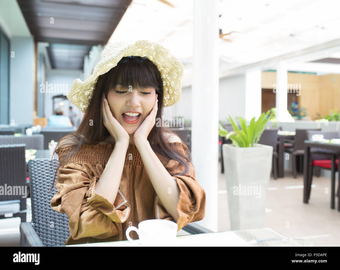 Young beautiful girl enjoy and relaxing  her breakfast in the open atmosphere restaurant, Thailand Stock Photo