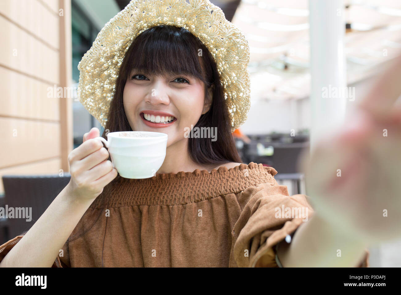 Young beautiful girl enjoy and relaxing  her coffee in the outdoor atmosphere restaurant, Thailand Stock Photo
