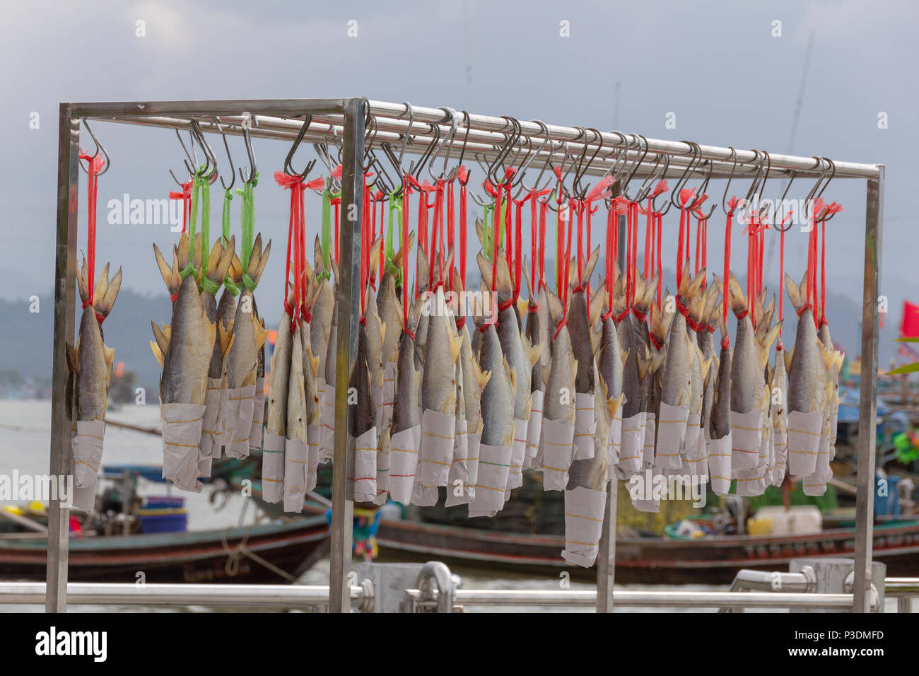 Sun dried salted fish hangs on wire Stock Photo