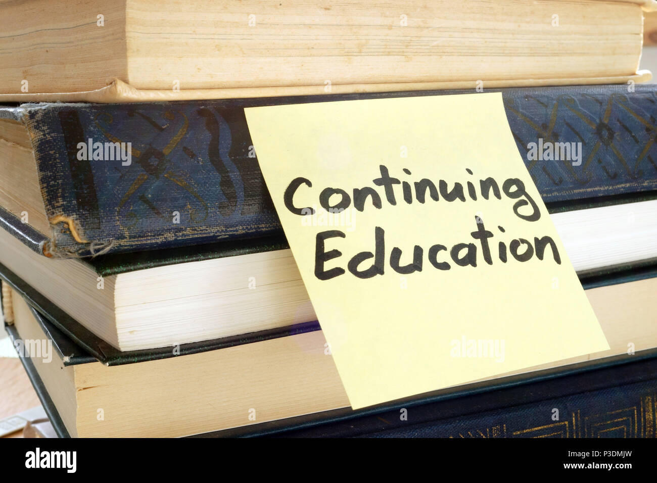 Memo stick with words Continuing education and books. Stock Photo