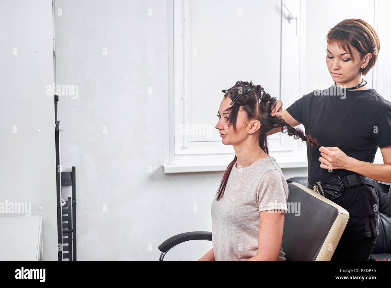 hair stylist making new haircut to brunette woman in salon Stock Photo