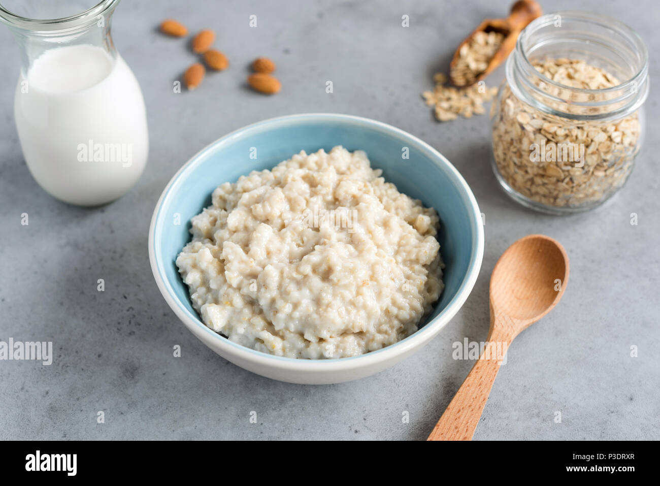 Steel cut oats, oatmeal porridge in bowl. Healthy breakfast on grey
