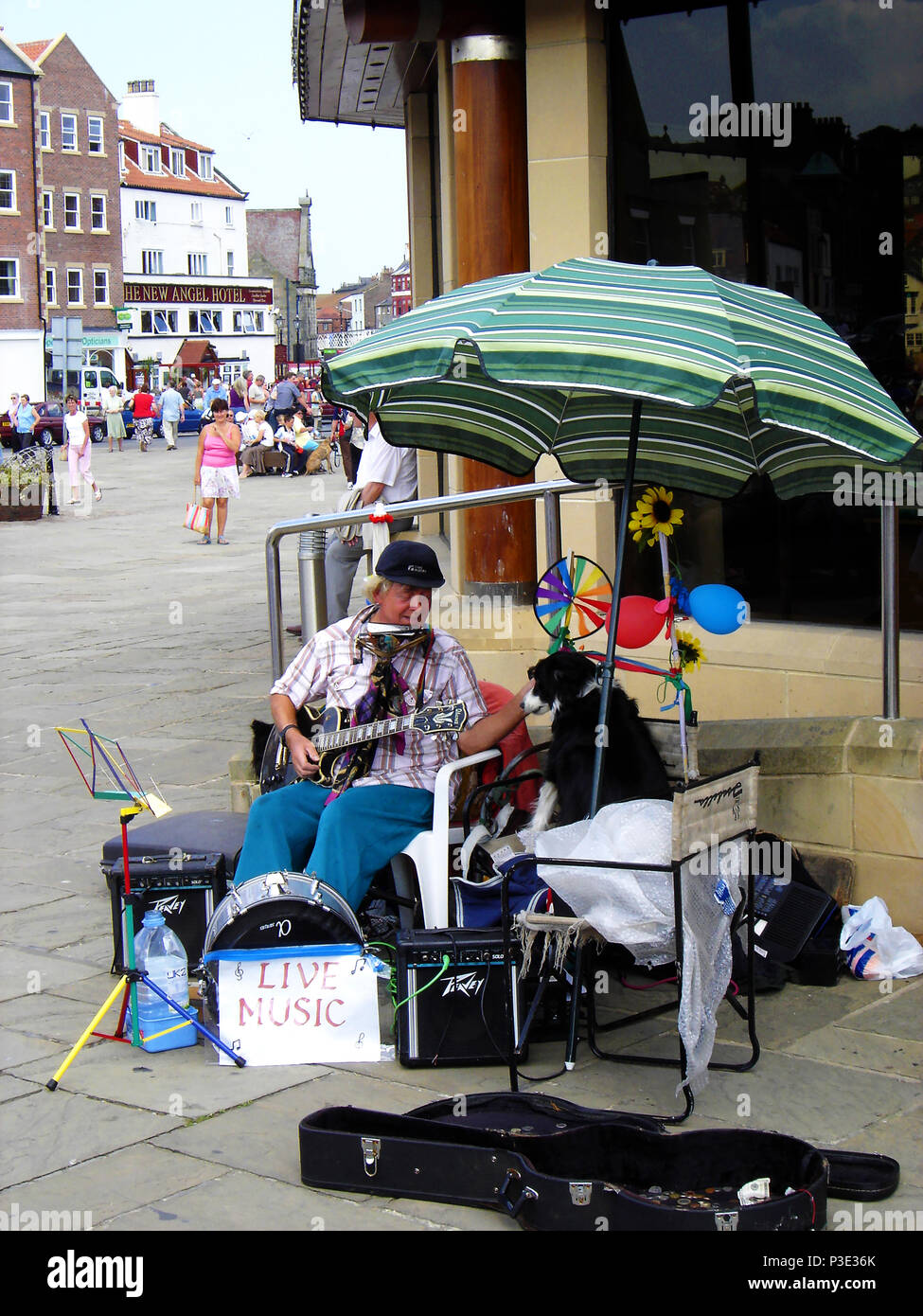LIVE MUSIC - One man and his dog - busker plays for  tourists and locals at Whitby, North Yorkshire, UK Stock Photo