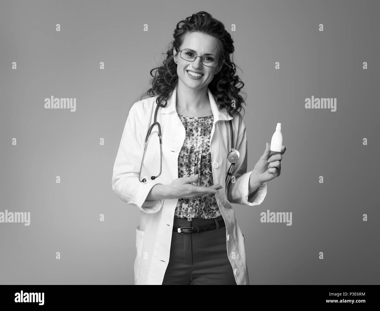happy pediatrist doctor in white medical robe recommending nasal spray isolated on background Stock Photo