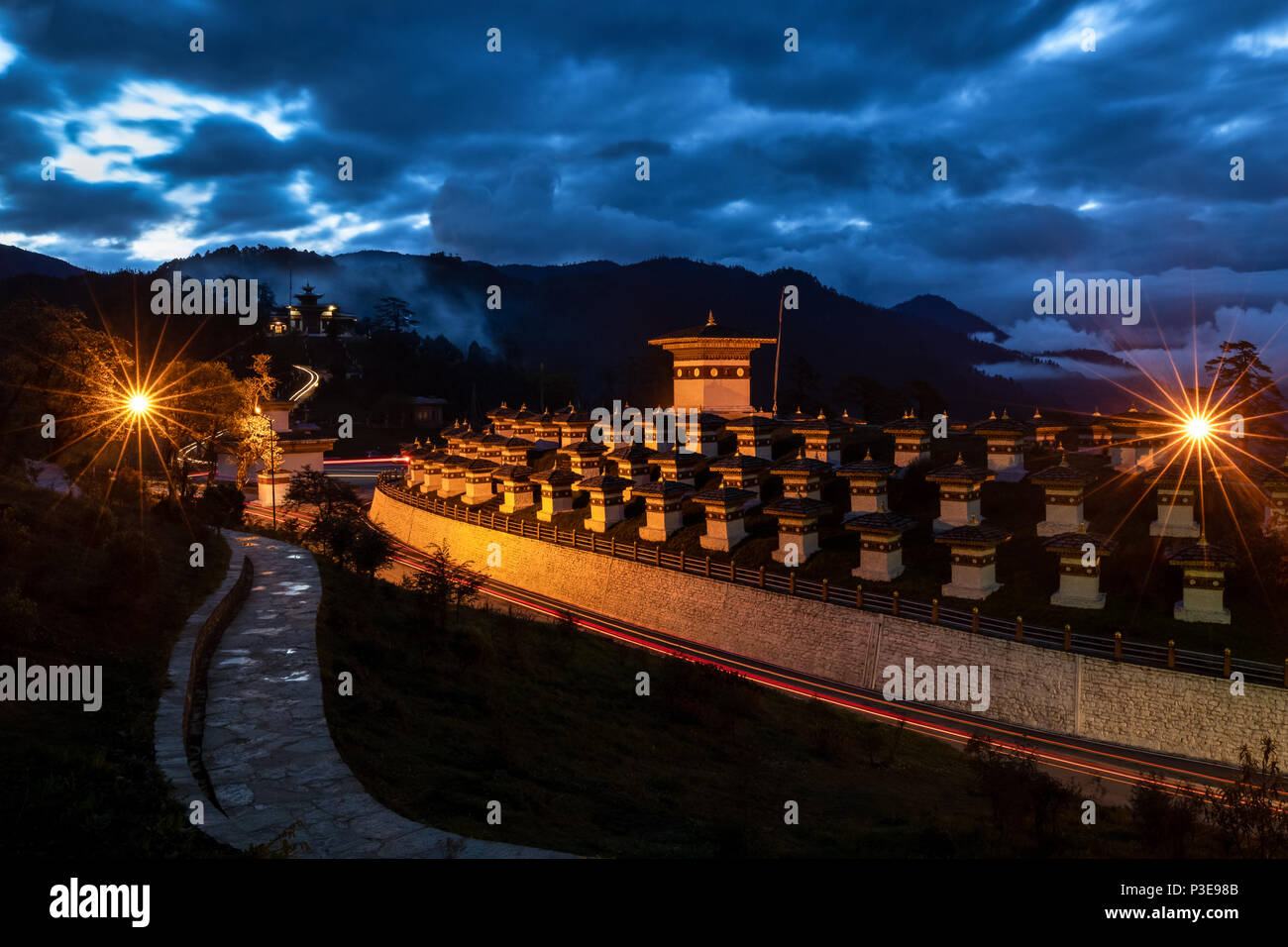108 memorial chortens of Dochula shining in its glory at dusk with heavy clouds giving company to the blue sky Stock Photo